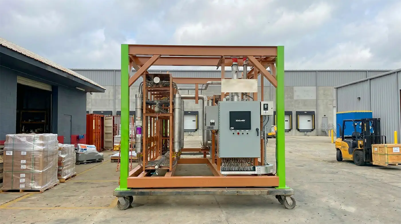 Large industrial process skid with pipes and control panel.