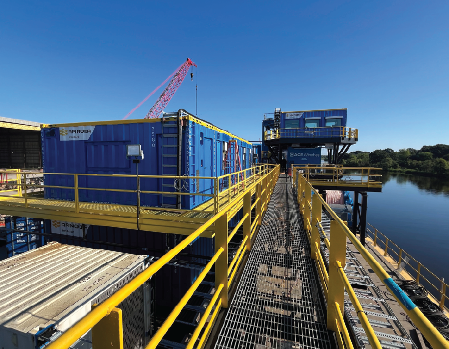 Modular offshore accommodation and control room units installed on a cable-lay barge with elevated access walkways.