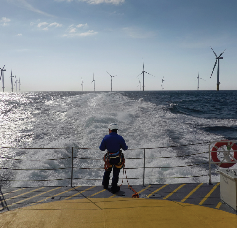 Offshore wind turbines viewed from a vessel operating within a wind farm during offshore construction activities.