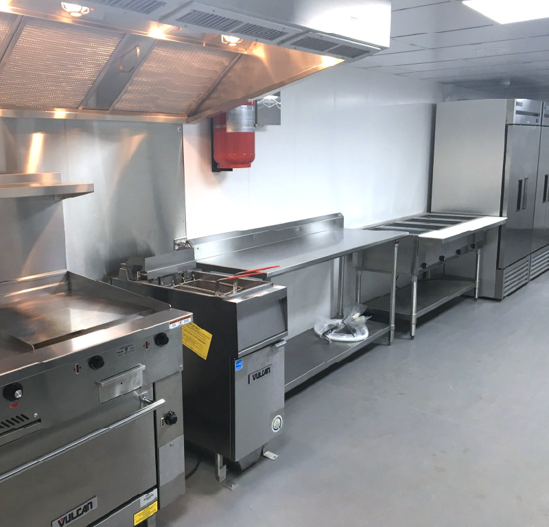 Stainless steel commercial kitchen inside a modular offshore facility.