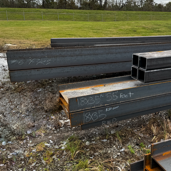 Structural steel beams with identification markings staged for fabrication and material traceability in offshore construction.