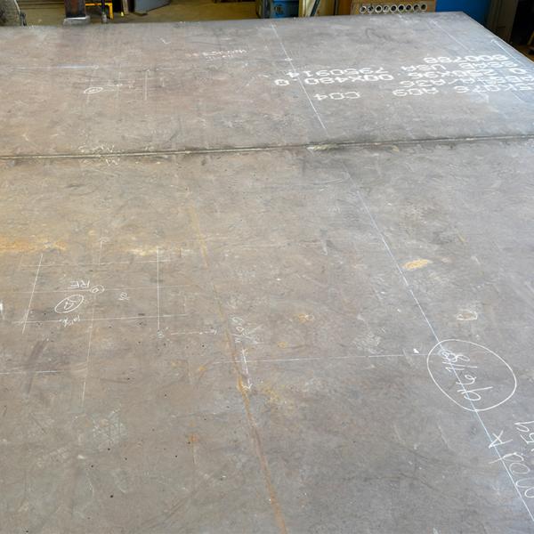 Steel plate with fabrication layout markings used for traceability and offshore module manufacturing.
